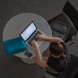 student typing on laptop